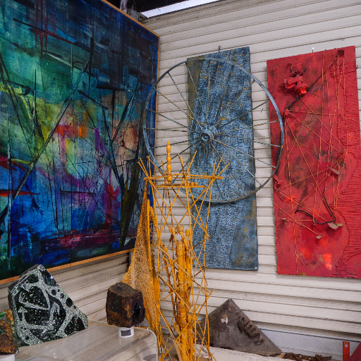 Studio exterior — large paintings and metal sculptures in the yard