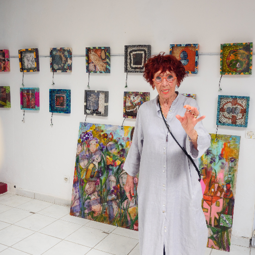 Madeleine Molinier standing before her new works — mixed-media framed paintings