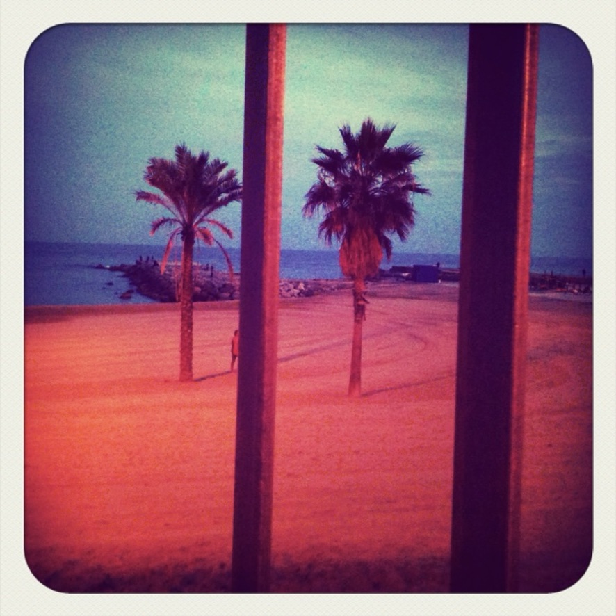 Barceloneta, early Hipstamatic — orange-red sand, turquoise sky, the colour shift extreme